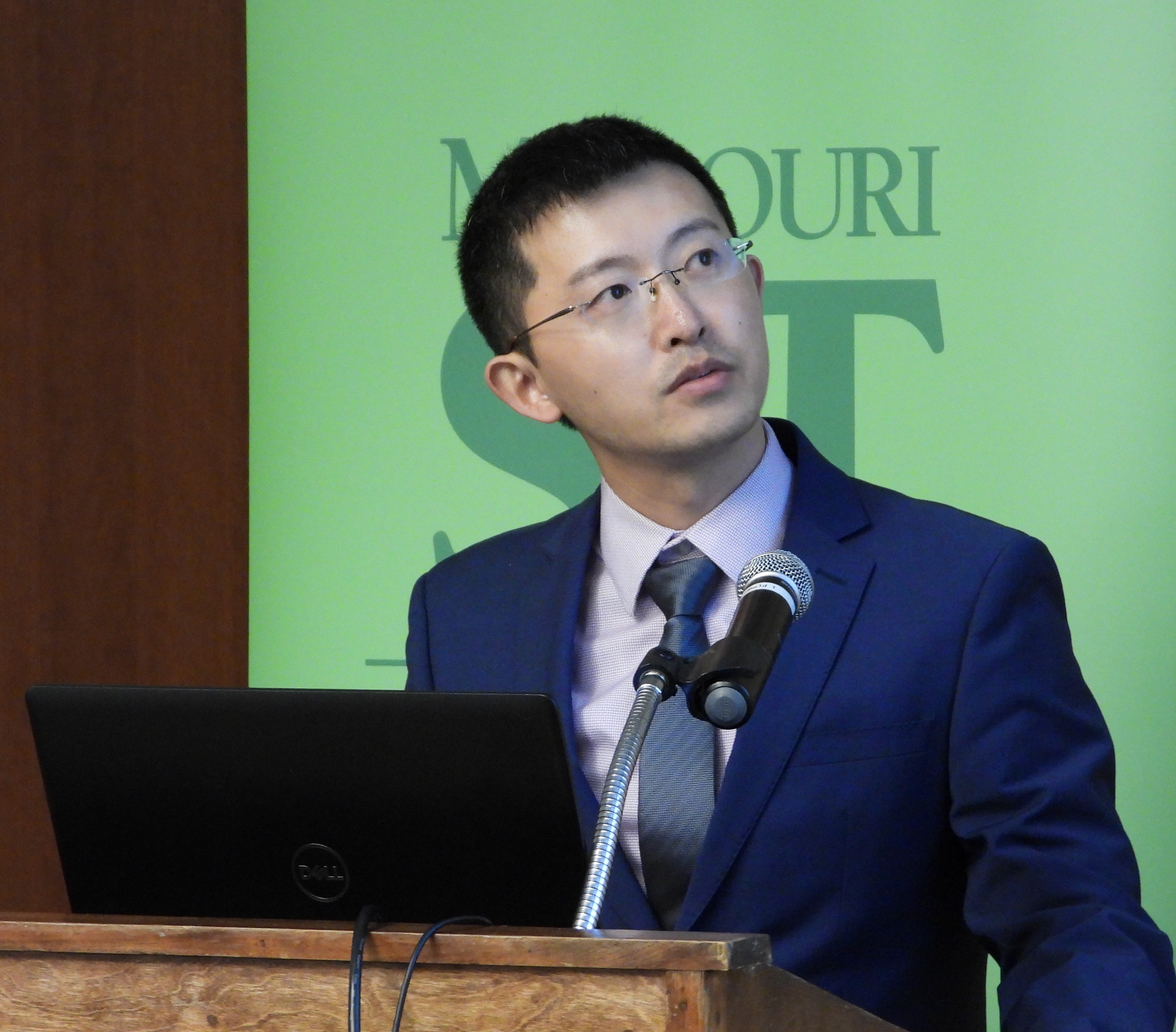 Second place recipient, Tao Liu, presenting behind a podium.